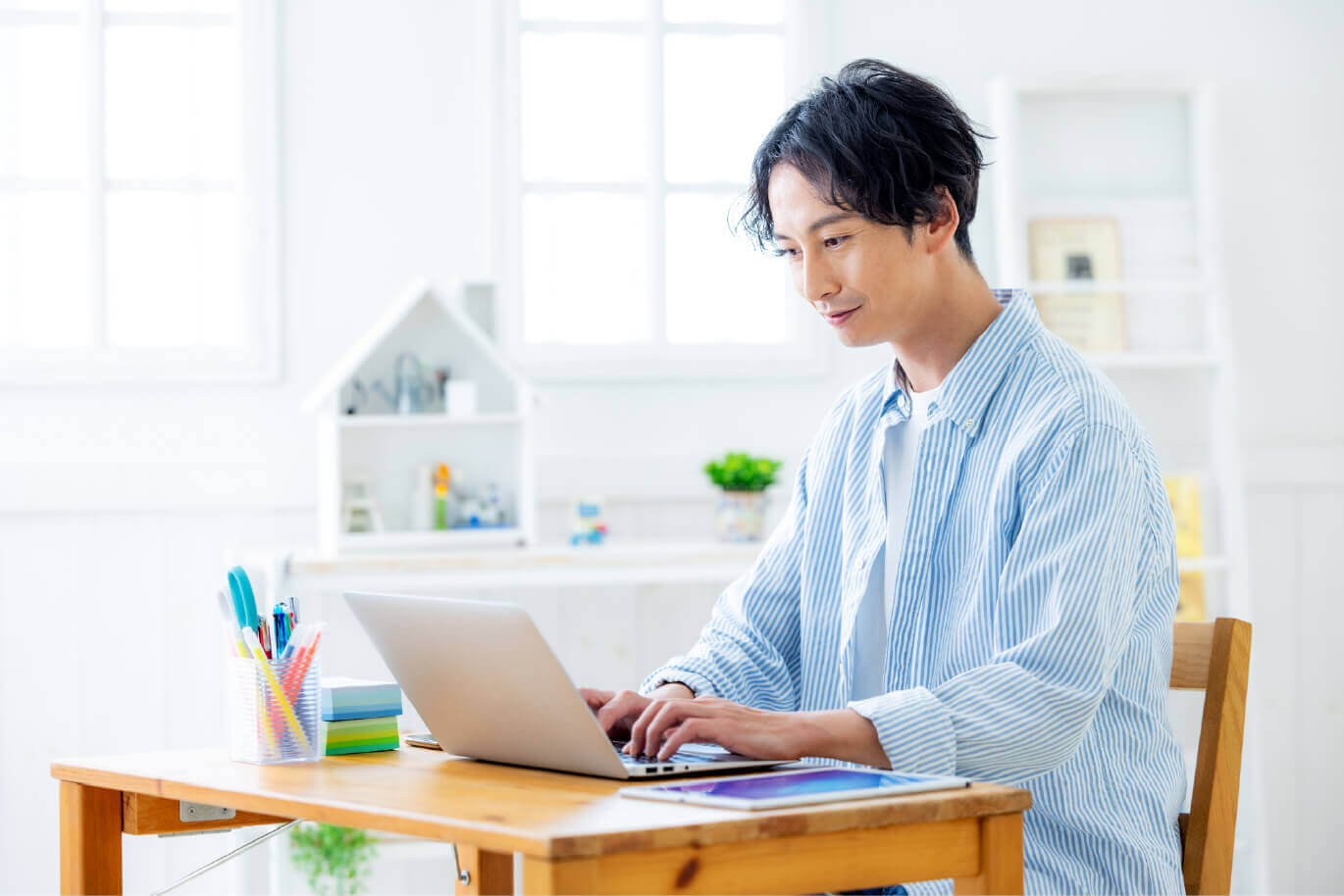 男性がデスクでパソコン作業している写真